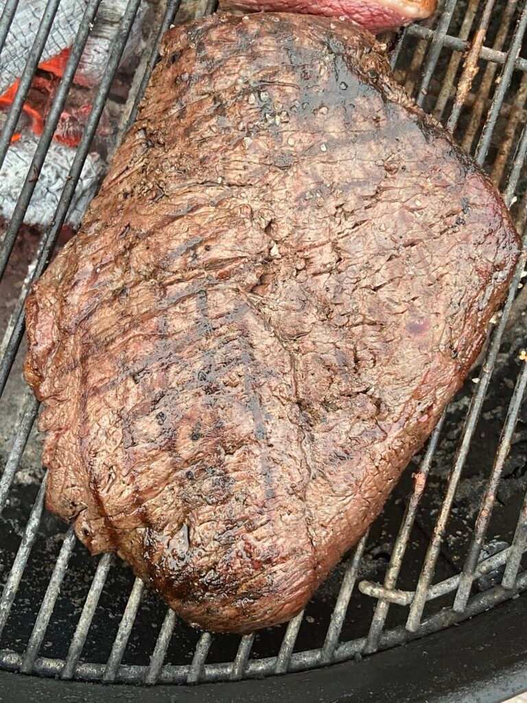 Picanha fatiada sendo grelhada na churrasqueira